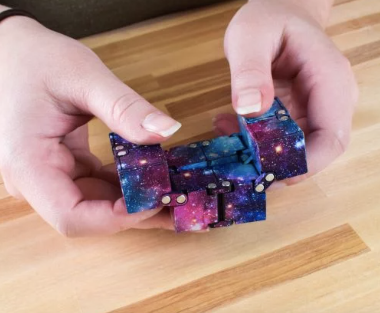 model playing with galaxy-print blue and purple fidget toy