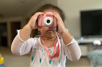 reviewer image of child holding pink camera up to their face
