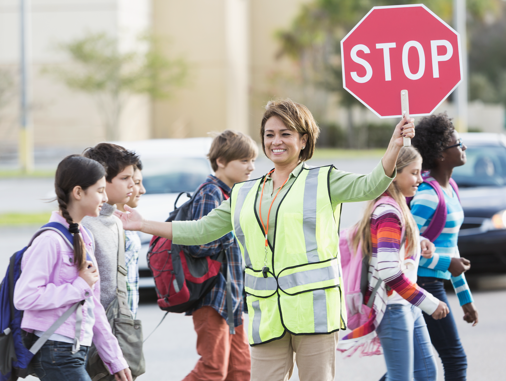 crossing guard helping kids cross the street for school