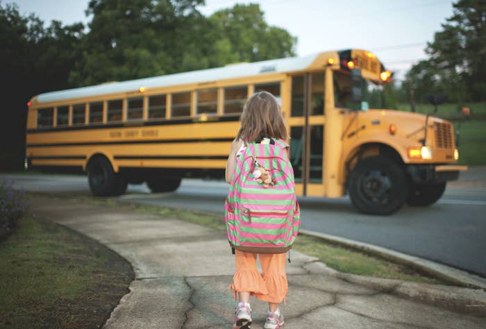 little girl getting on a school bus