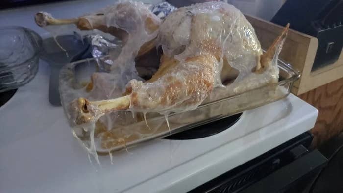 A roasted turkey coated in a thin plastic film that's melted