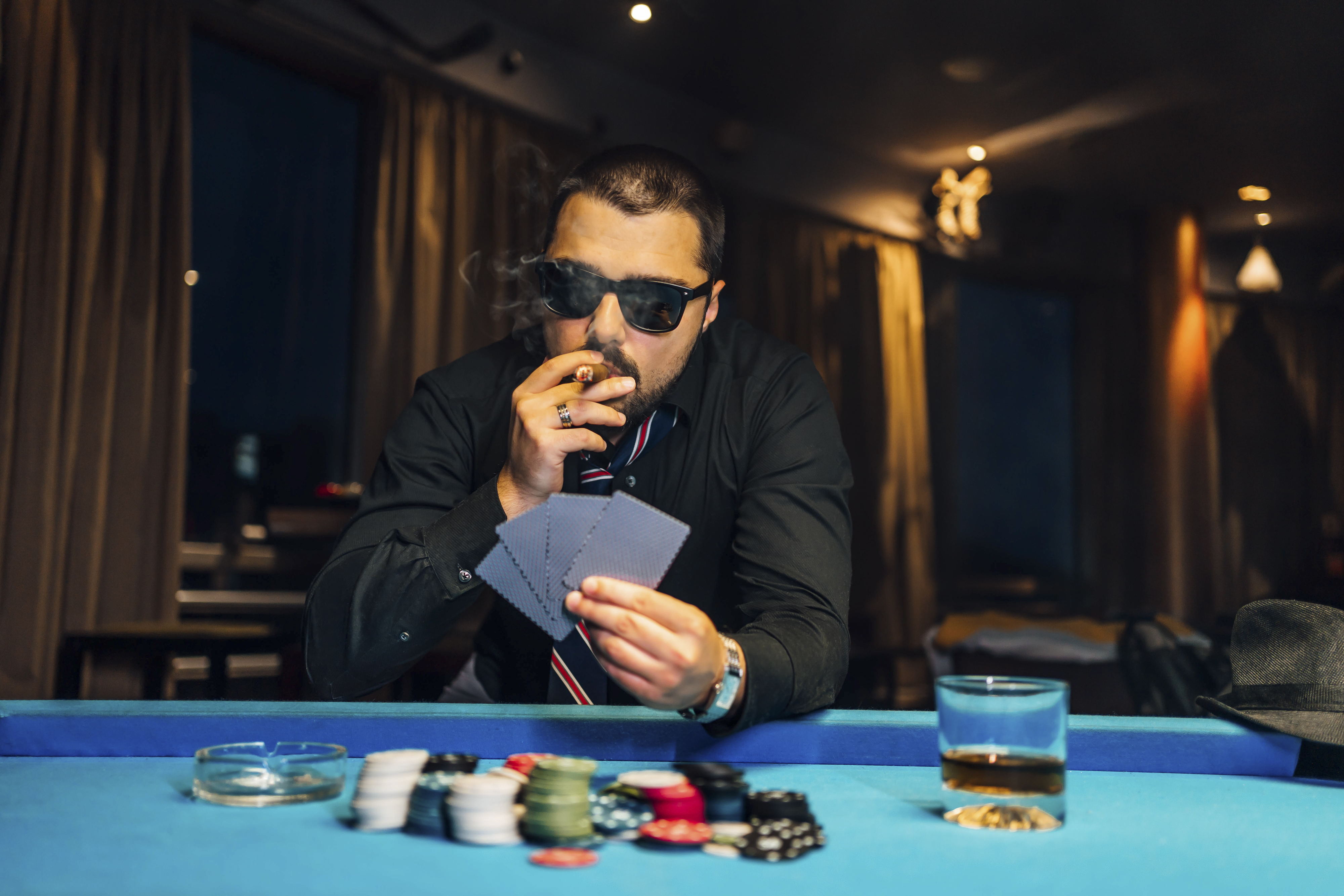 A man playing poker and smoking a cigar