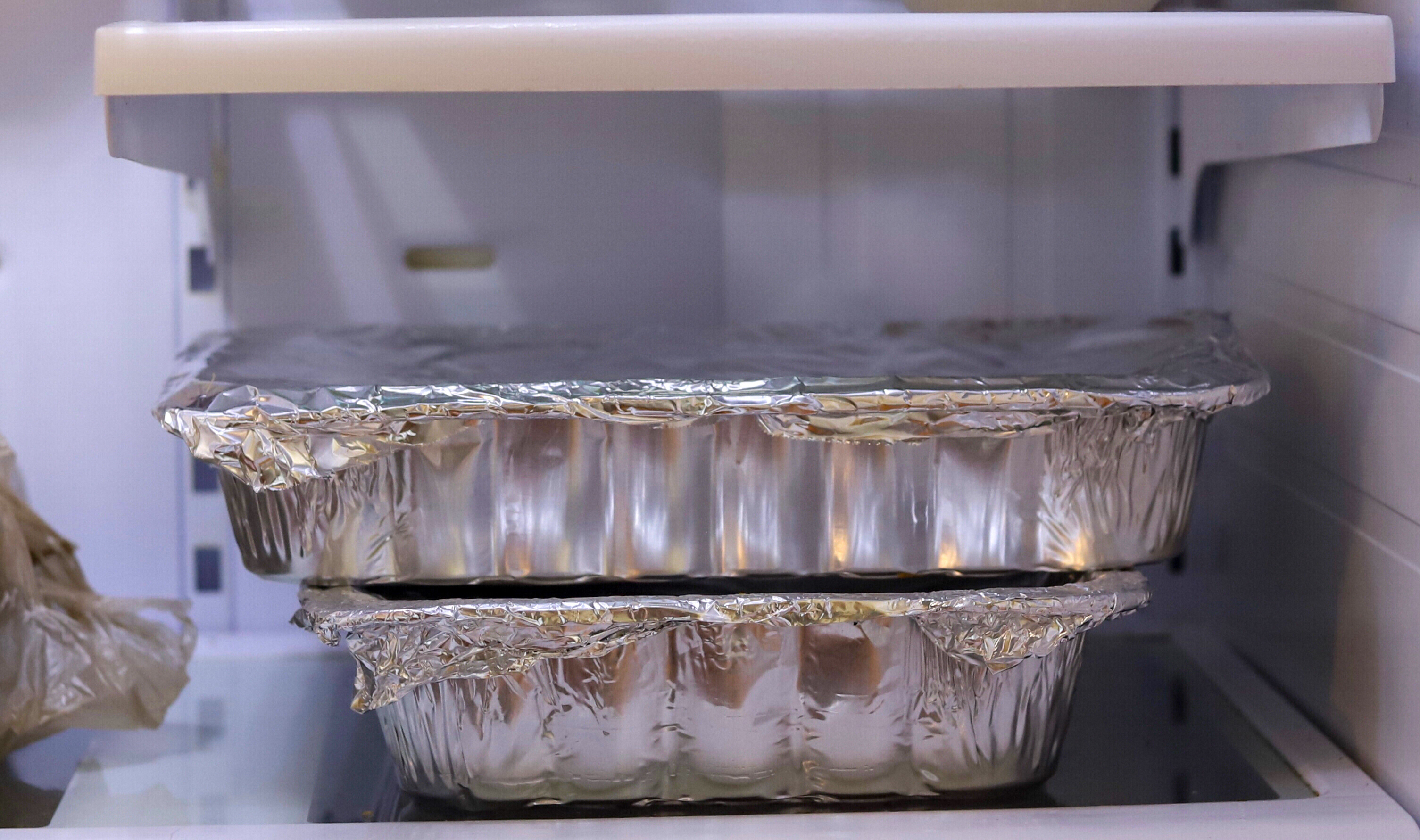 stacked aluminum containers in a refrigerator