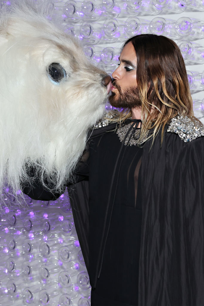 Close-up of a heavily made-up Jared kissing a furry animal face