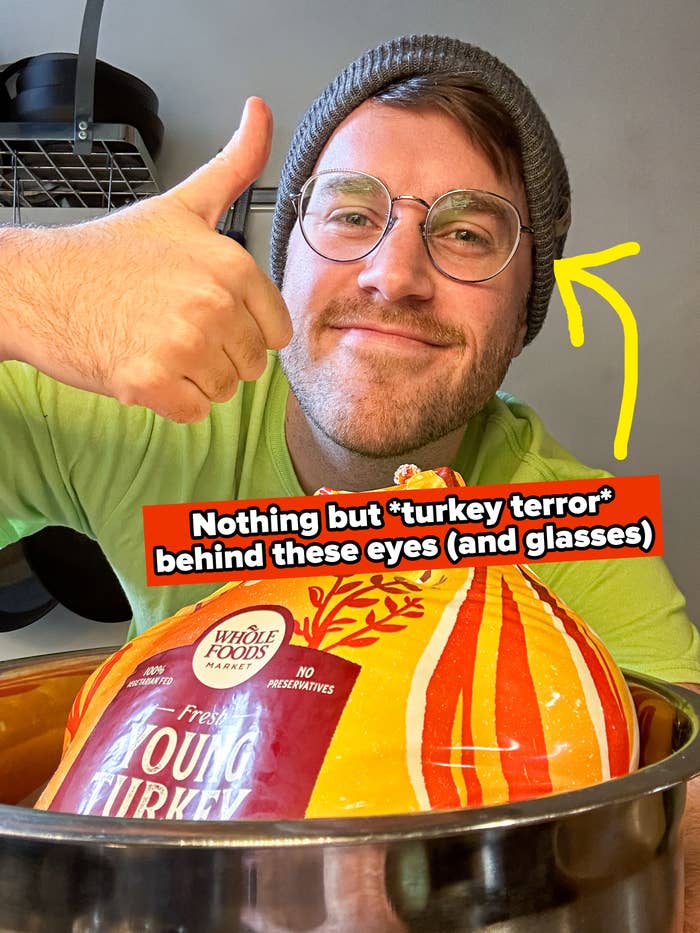 author giving a thumbs up in front of a turkey in a bag in his kitchen
