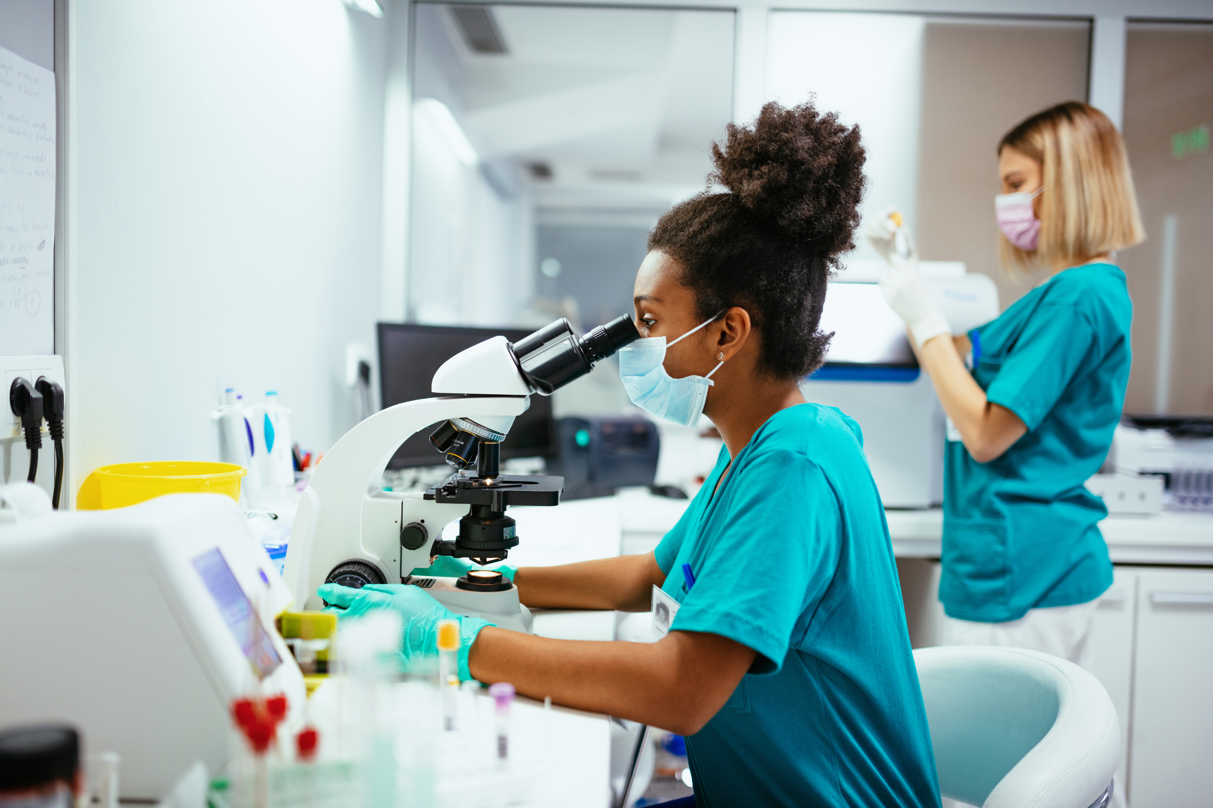 Lab worker looking through a microscope