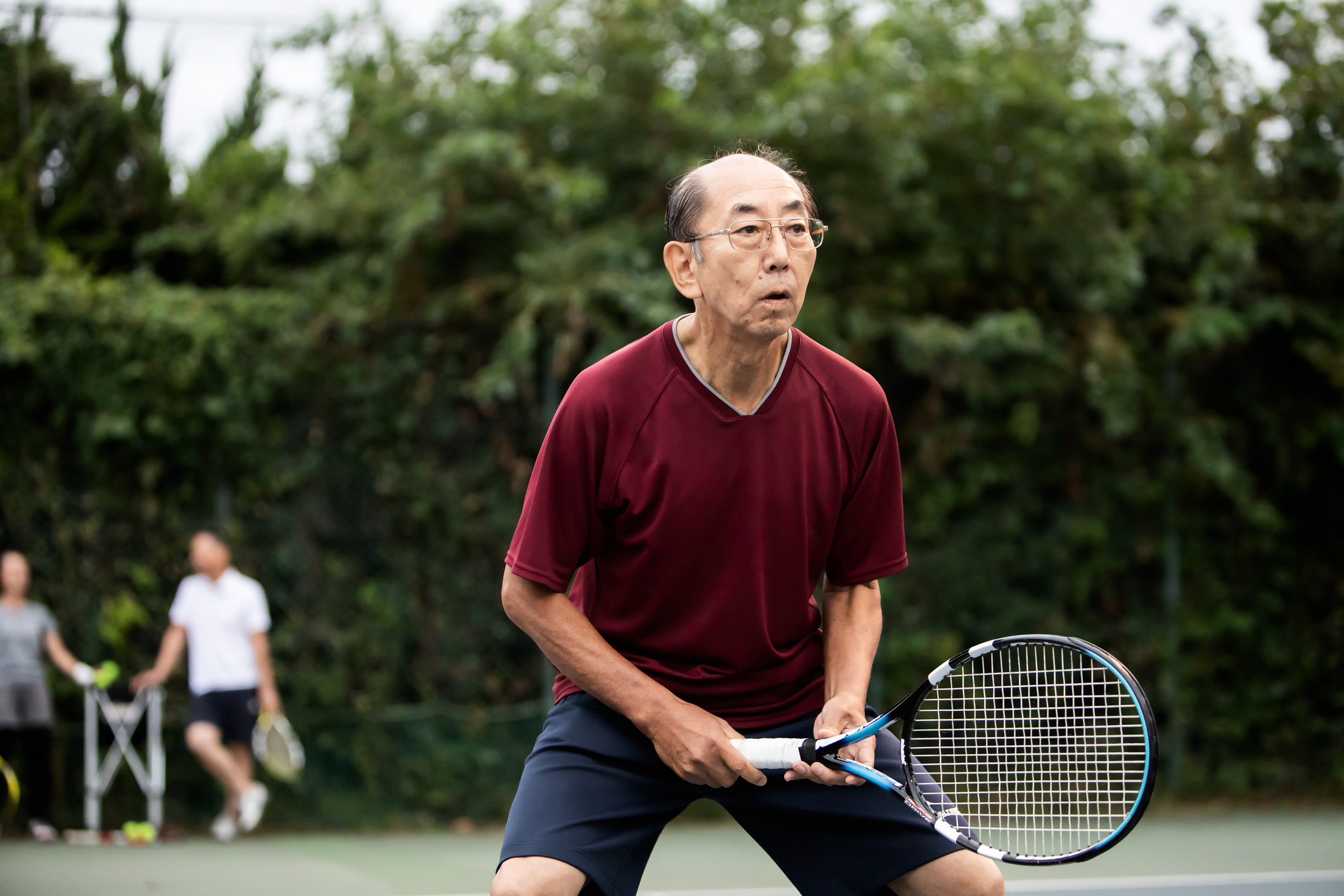 An older man is playing tennis