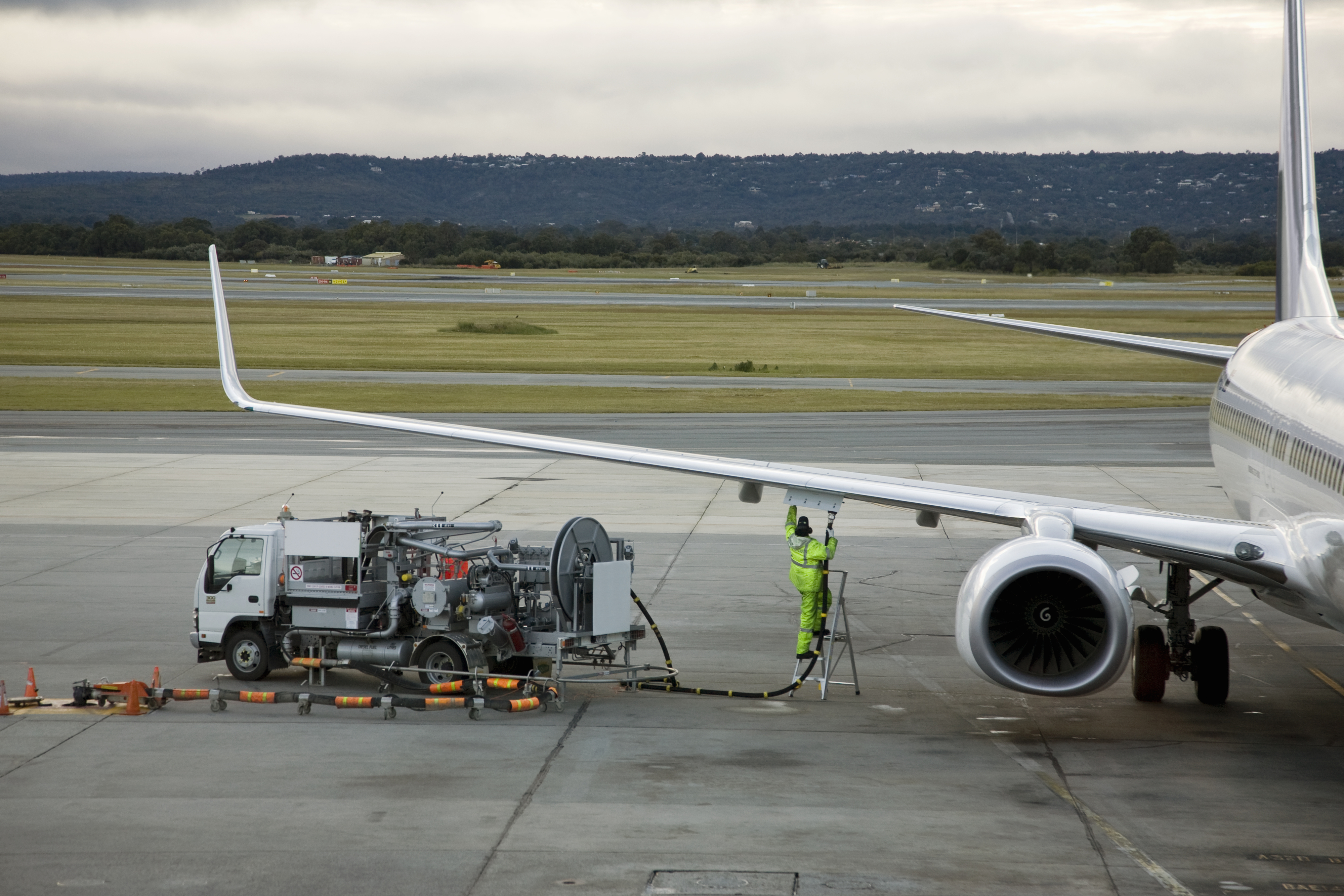 An airplane is filled with fuel on the tarmac