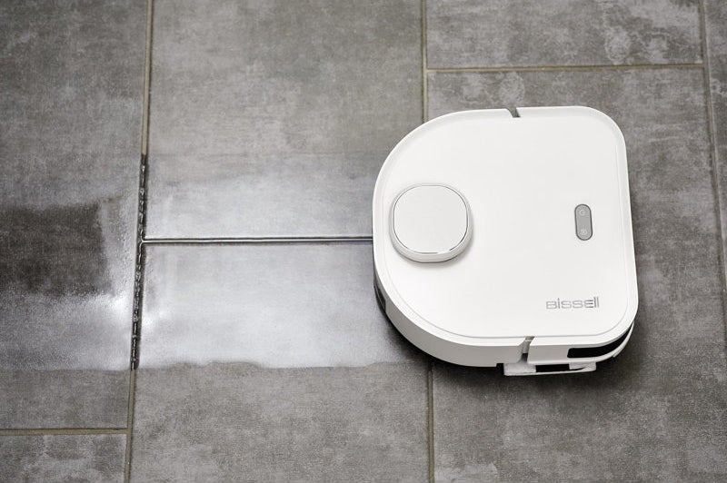 The robo mop leaving a trail of cleaned tile floor behind it.