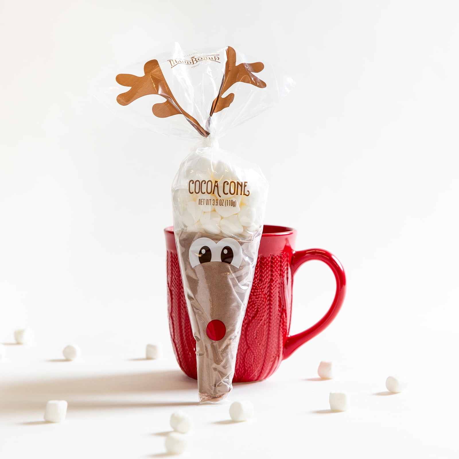 hot cocoa mix in a cellophane cone shaped bag with a reindeer face on it
