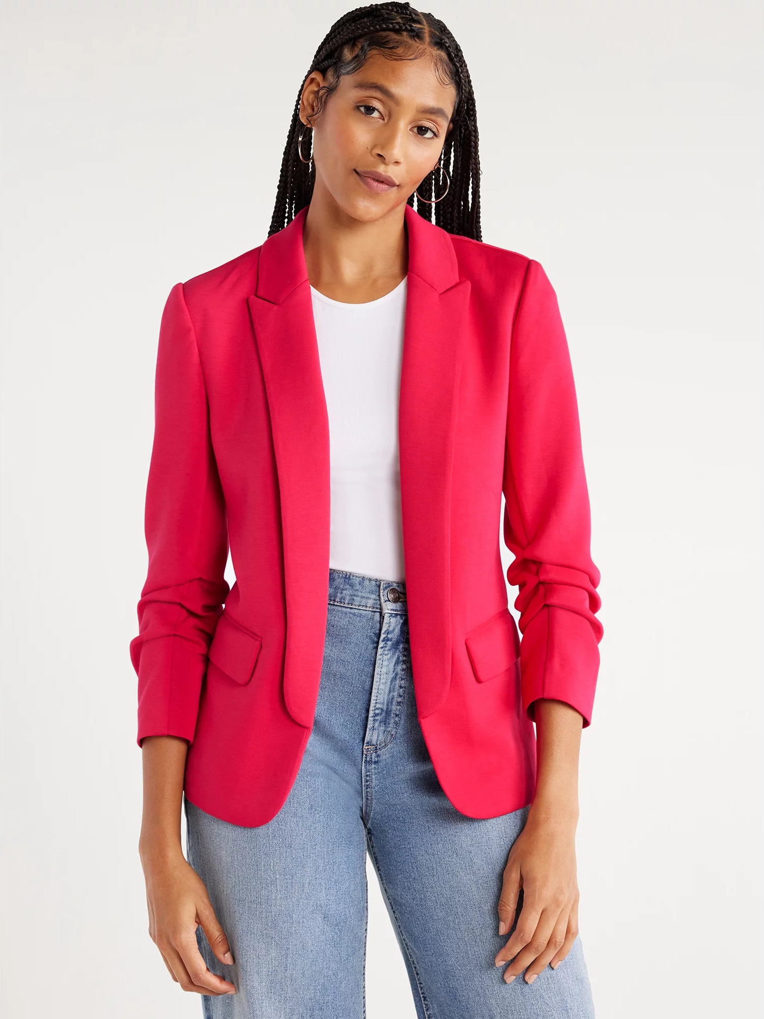 A model wearing the scrunched-sleeve blazer in pinkish red over a white tee and blue jeans