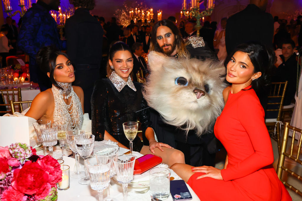 Close-up of Jared with members of the KarJenner clan at a Met Gala table, holding the cat head