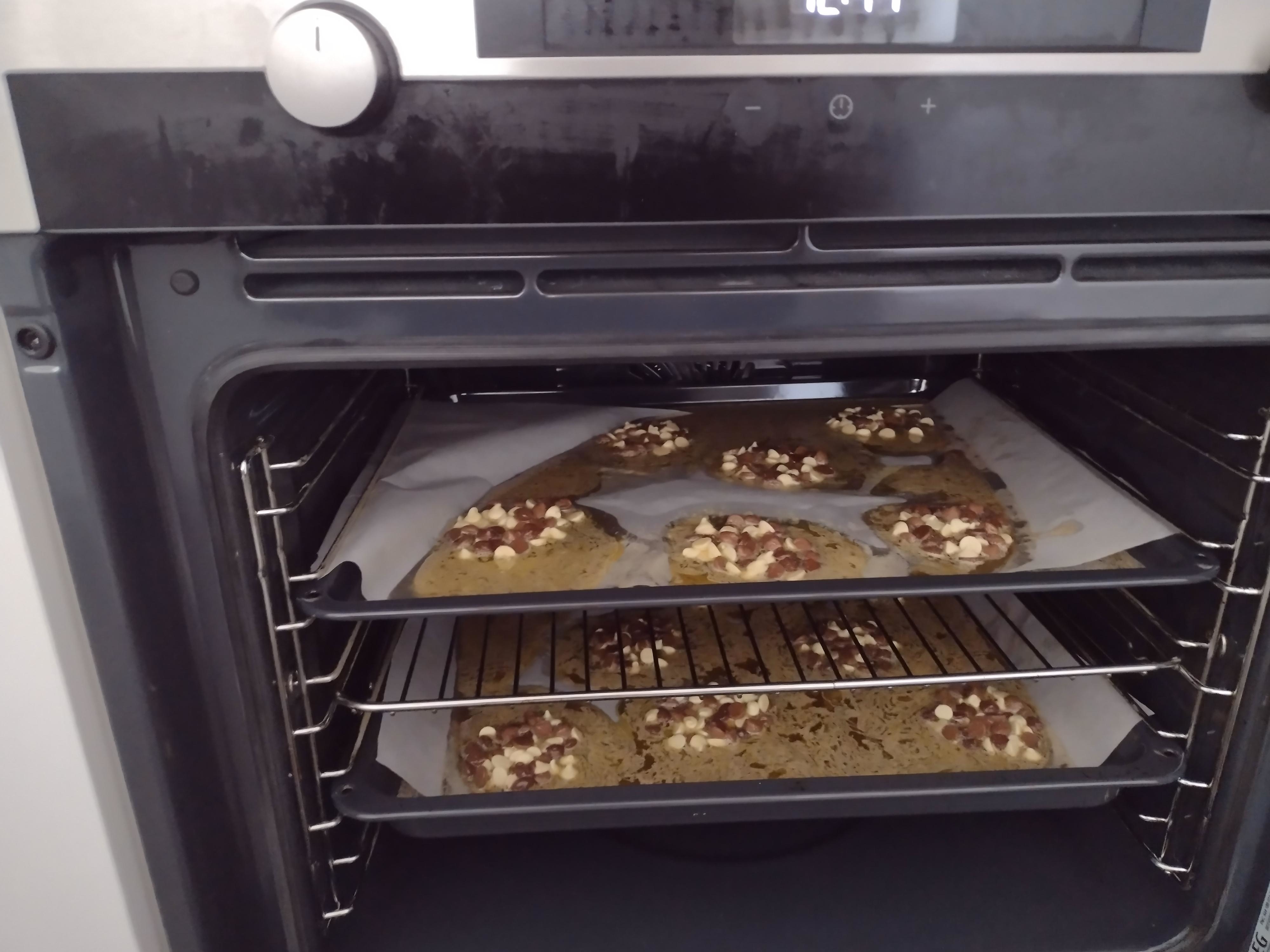 Melted cookies on trays in an oven