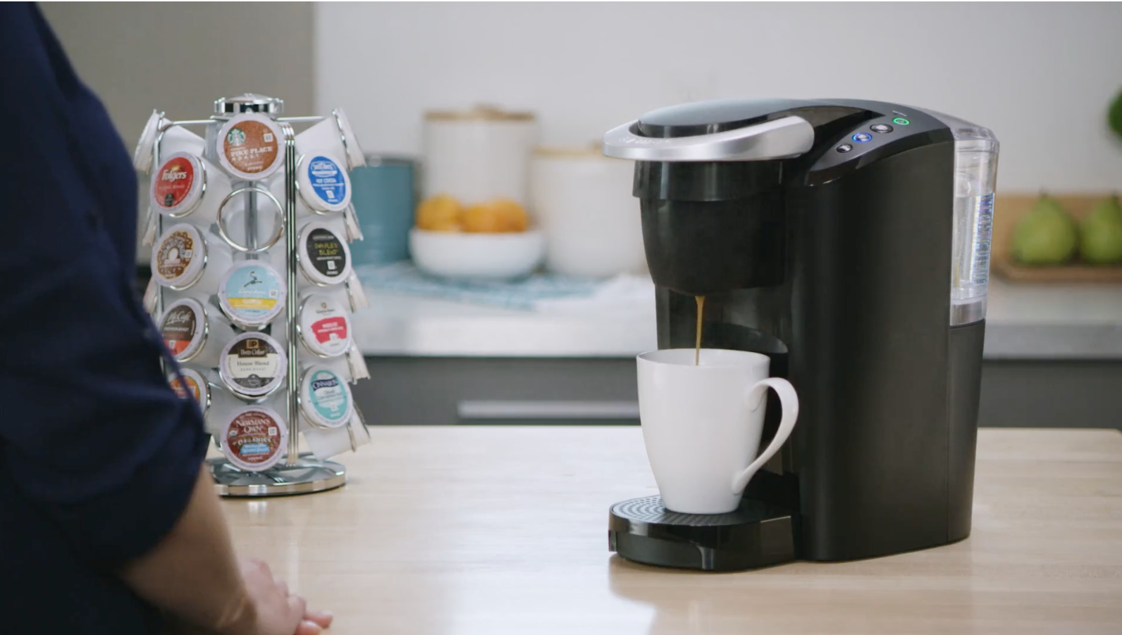 a black keurig machine making a cup of coffee on a kitchen counter