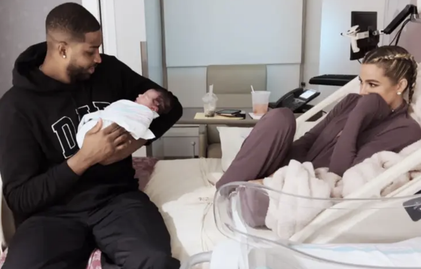 Tristan holding their newborn in the hospital as?Khloé’ looks on from