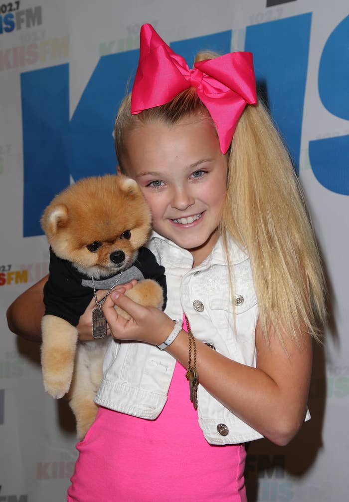 Young JoJo Siwa holding a dog