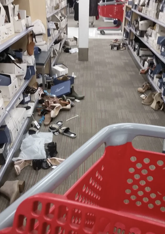 A bunch of shoes strewn on the floor and left a mess by a customer