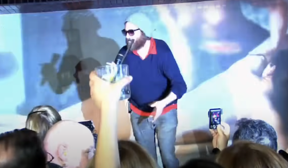 21 Low-Key Ridiculous Things Celebs Did For Money, Clout, Or Attention 52 Screenshot from "I'm Still Here" oh Joaquin in character with sunglasses and a beanie under bright lights