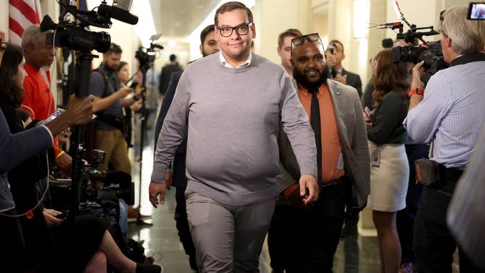 george santos is seen walking with cameras around him