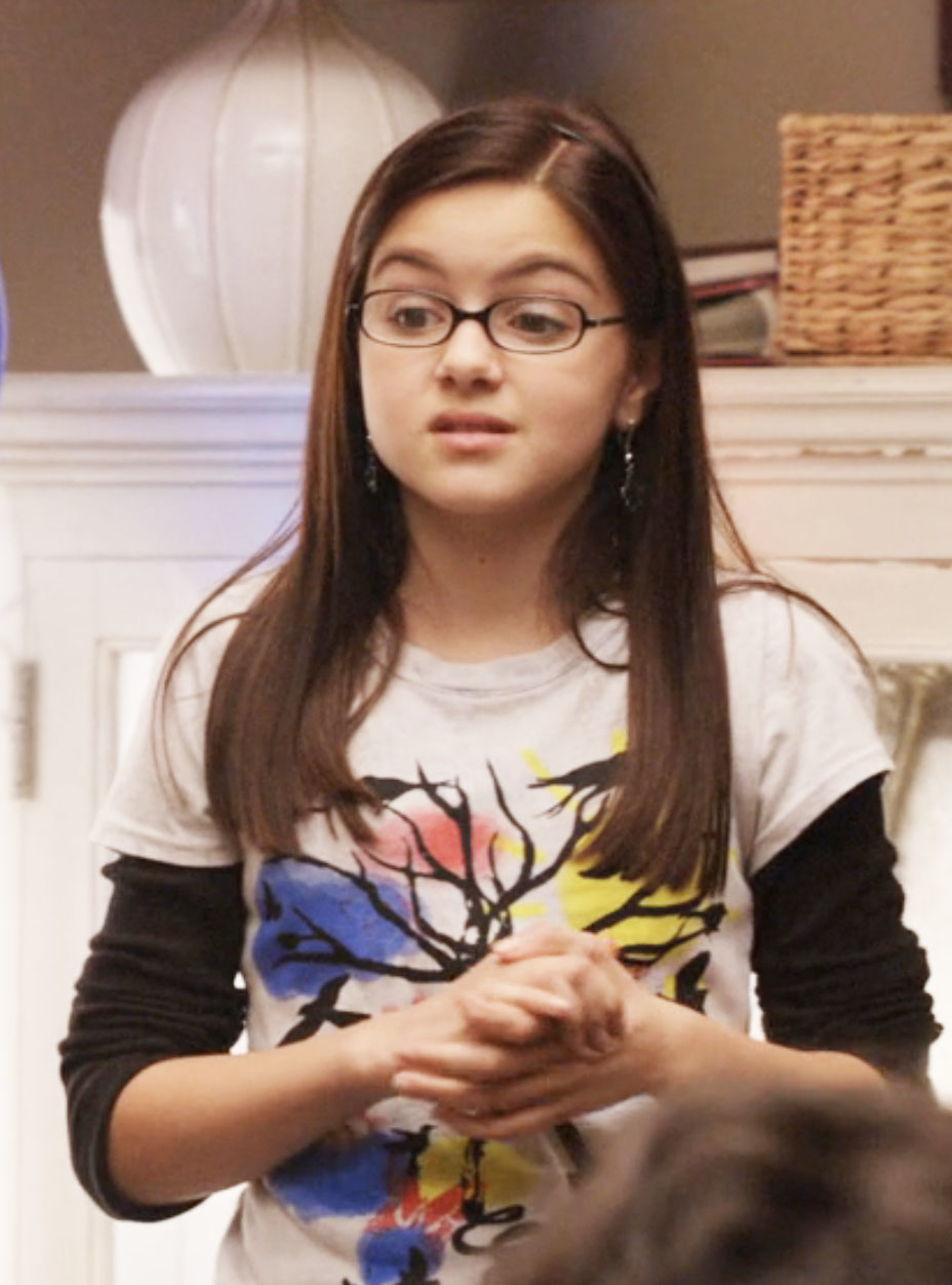 closeup of her character wearing glasses and a long-sleeve under a t-shirt