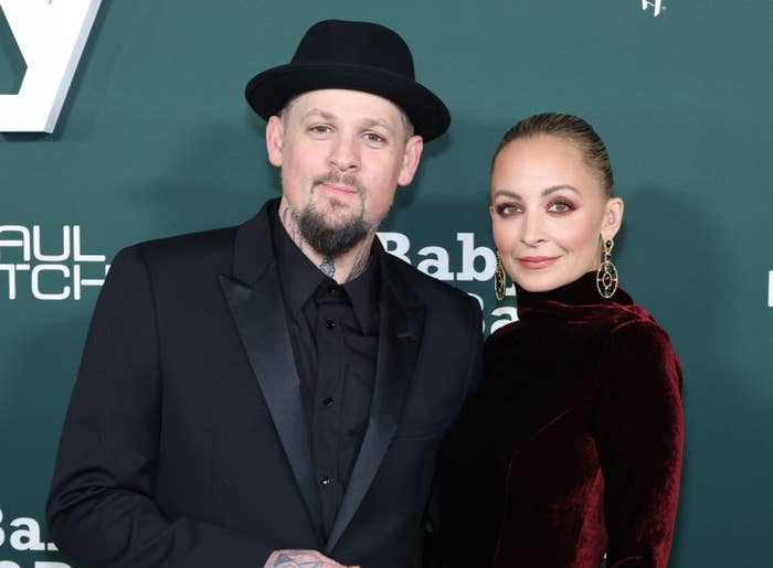 Closeup of Joel Madden and Nicole Richie on the red carpet smiling for photographers