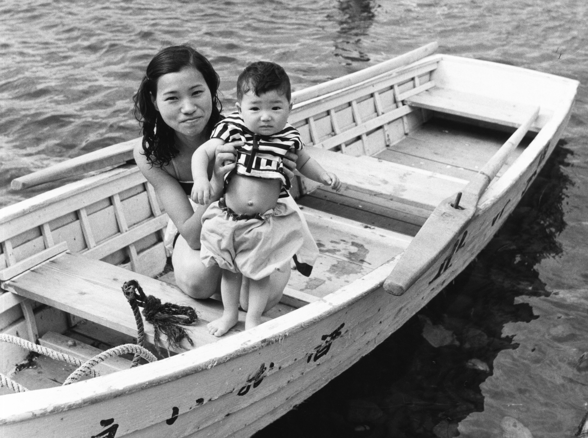 A woman on a boat holding her baby boy