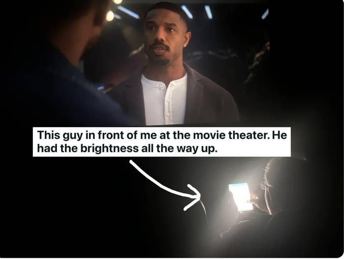 A person with their bright phone on in a movie