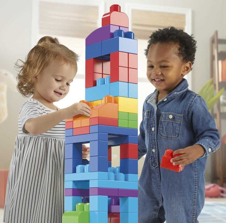 two children playing with colourful building blocks