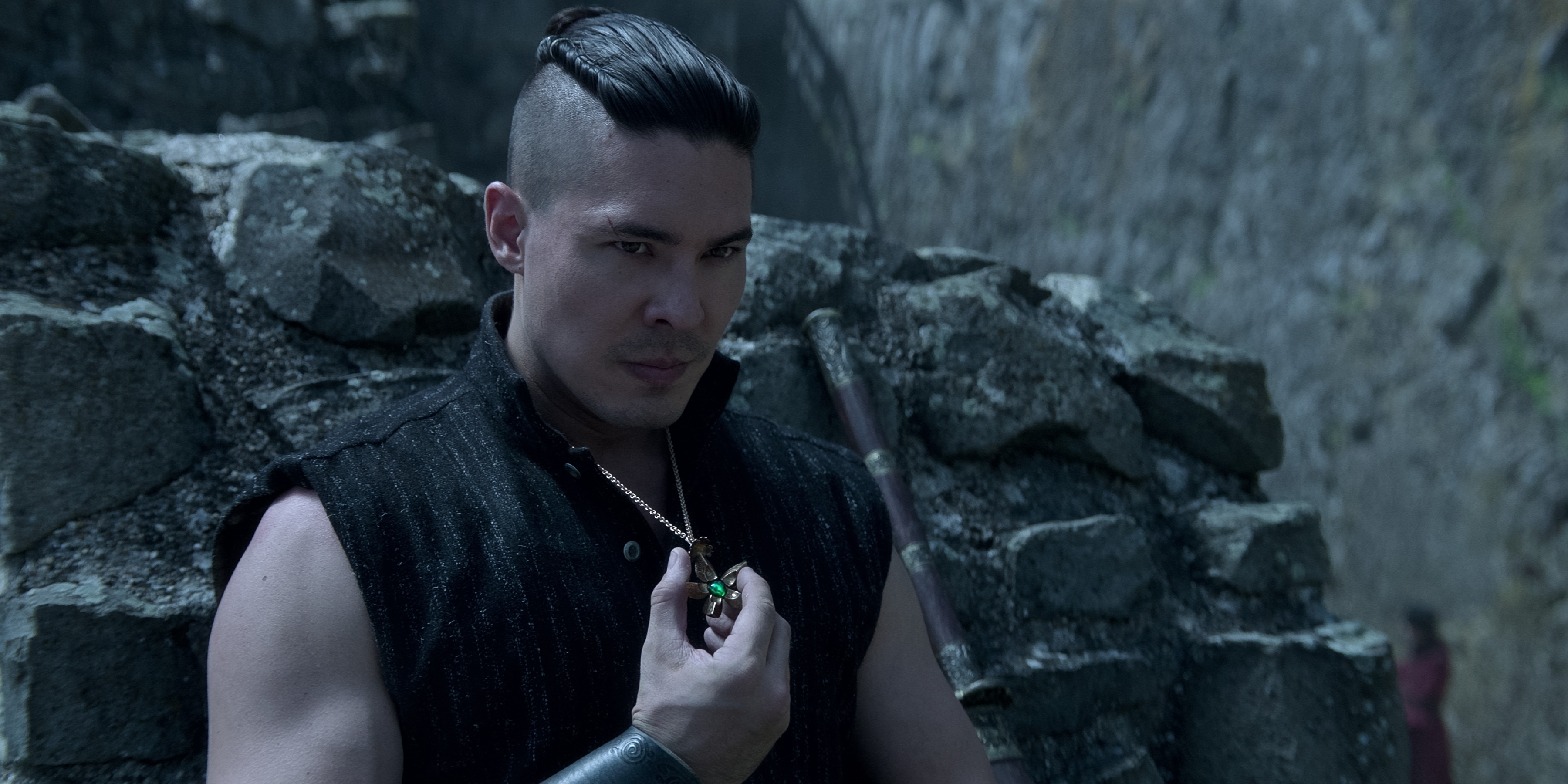 Lewis Tan holding onto a necklace in a scene from &quot;Shadow and Bone&quot;