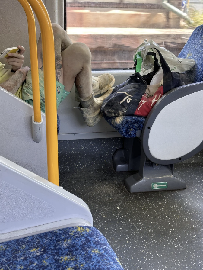 a man with his dirty feet on a bus seat