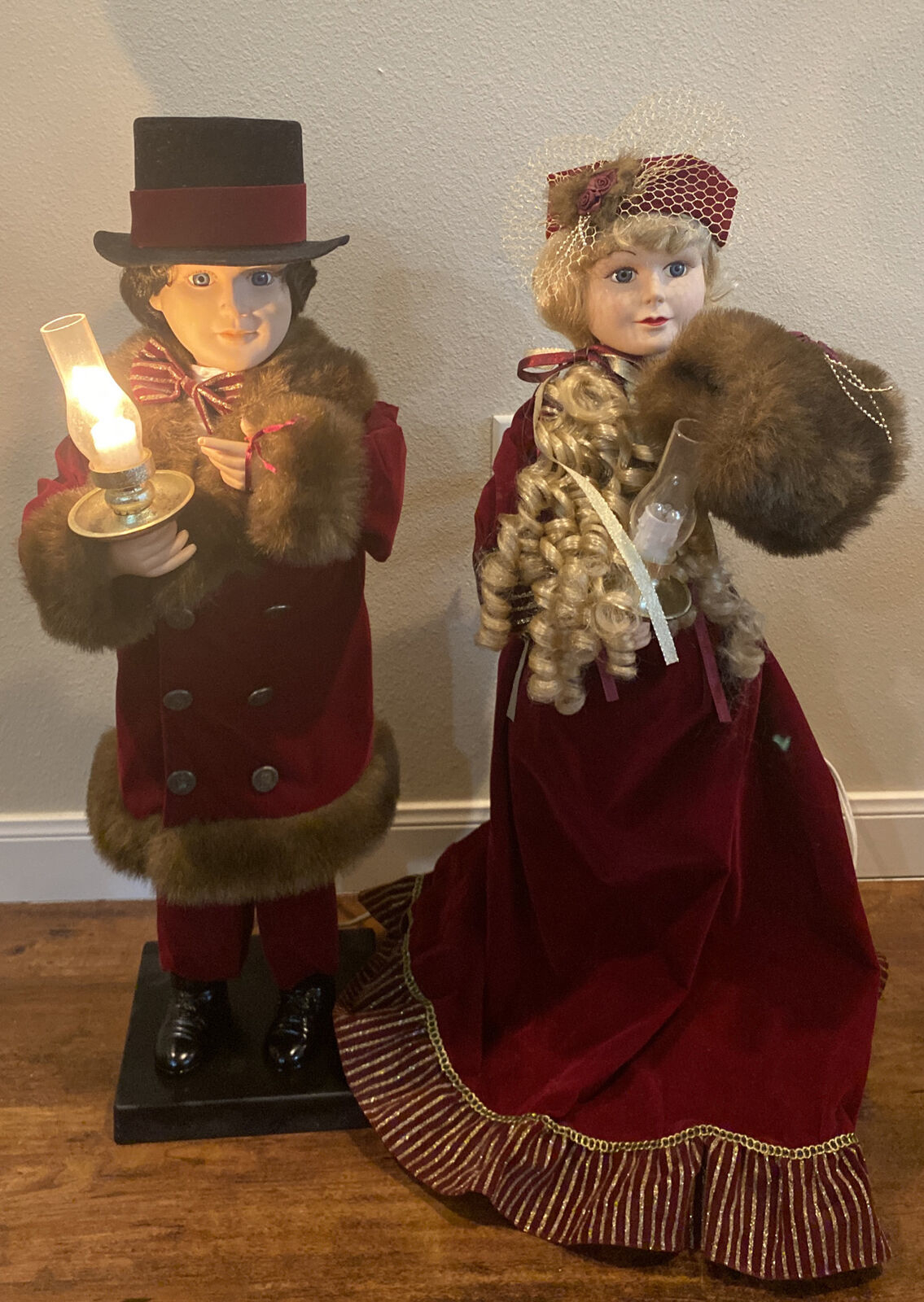 They&#x27;re carrying candles, and one&#x27;s wearing a top hat, and the other is in a velvet gown