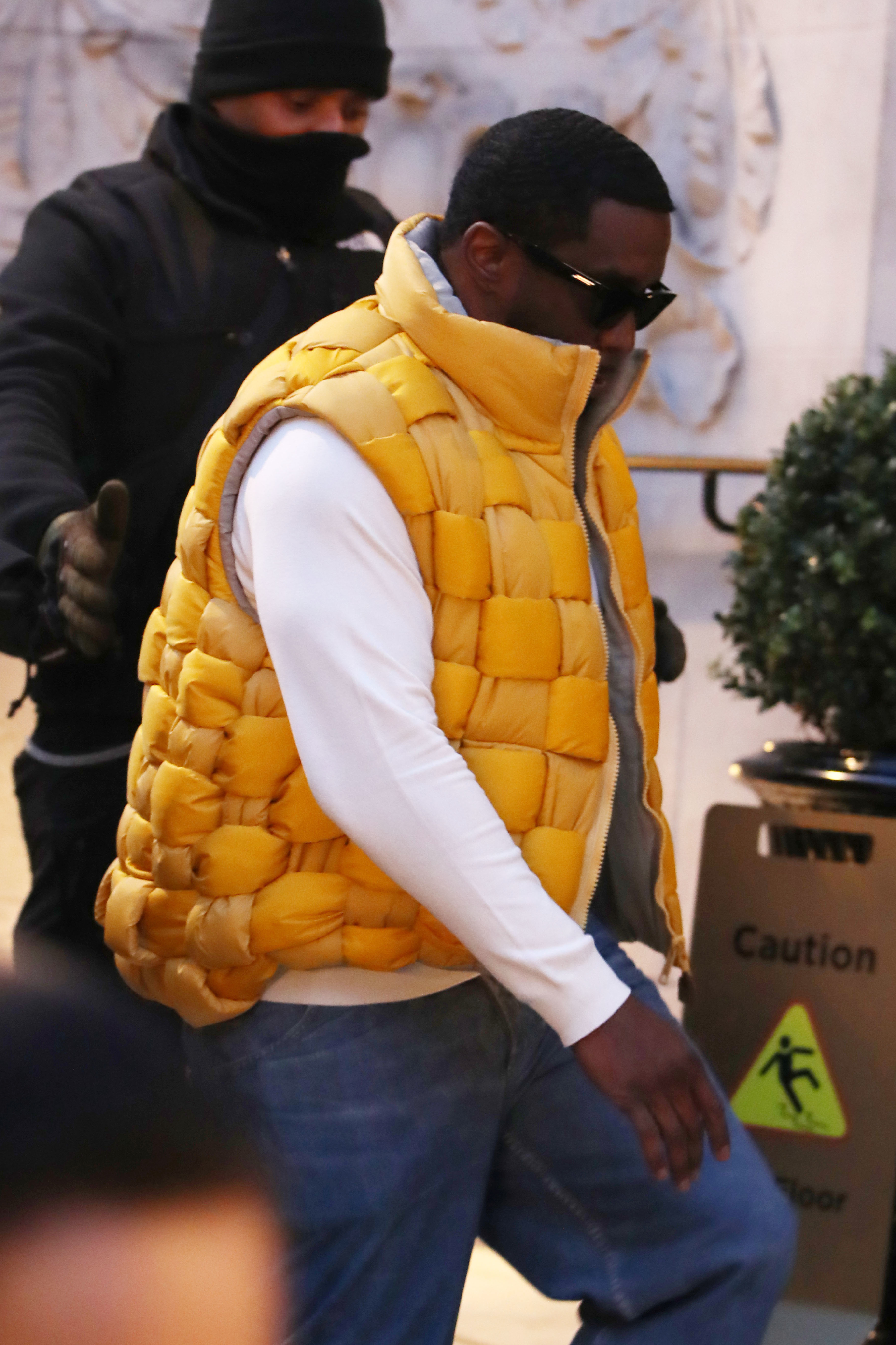 Closeup of Diddy walking outside in a puffer vest