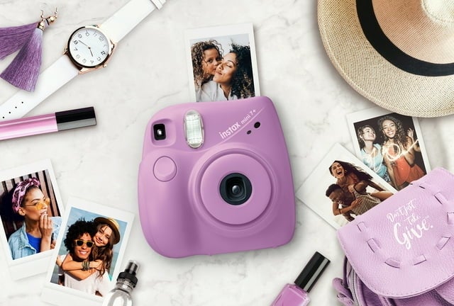 the camera in purple with printed photos on a table