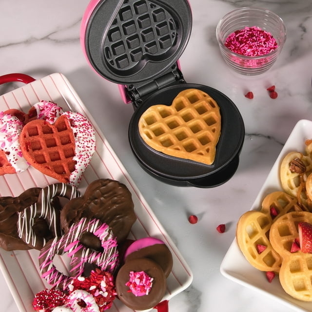the waffle maker with a waffle inside, surrounded by other waffles