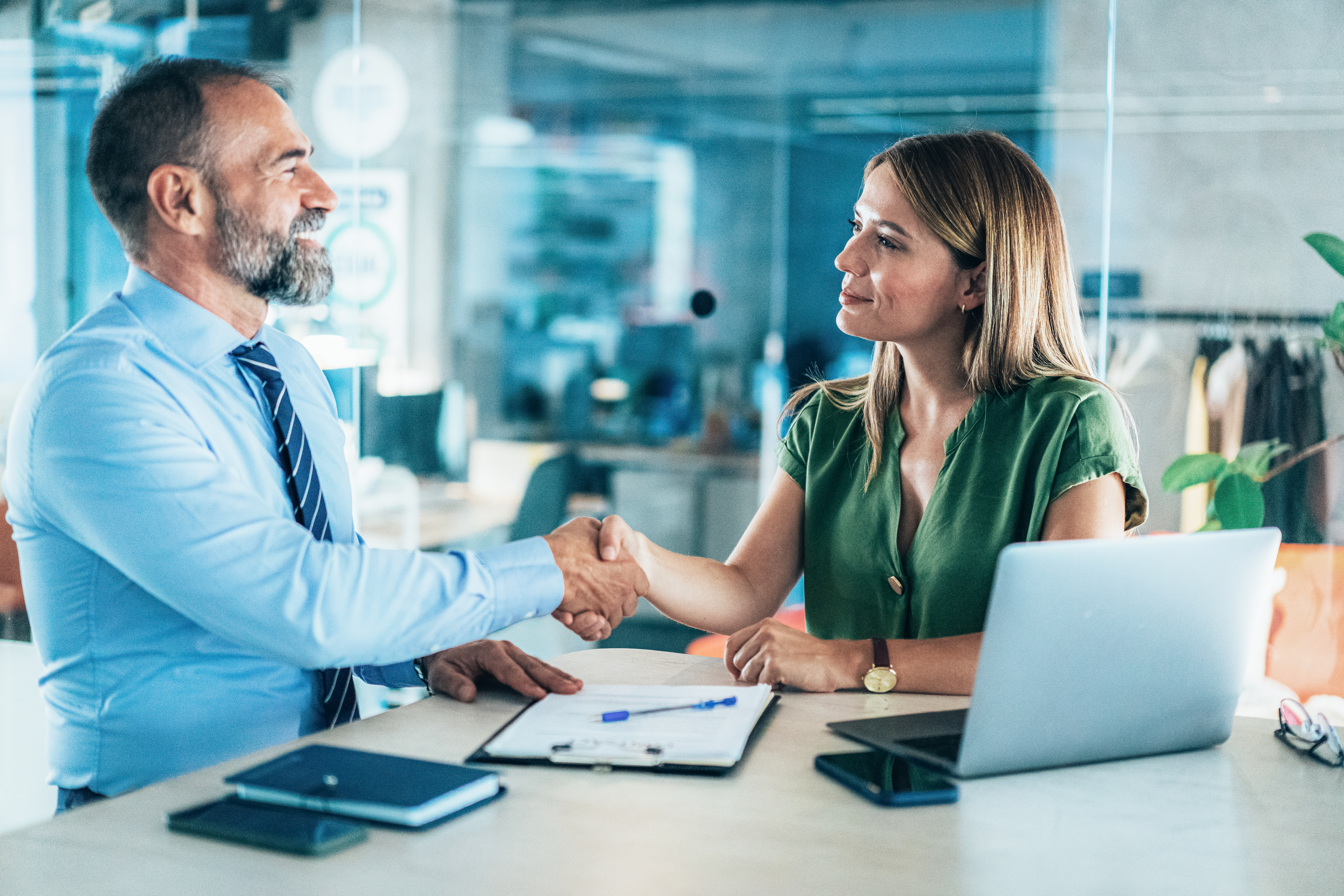 a woman and man shaking hands in a business meeting