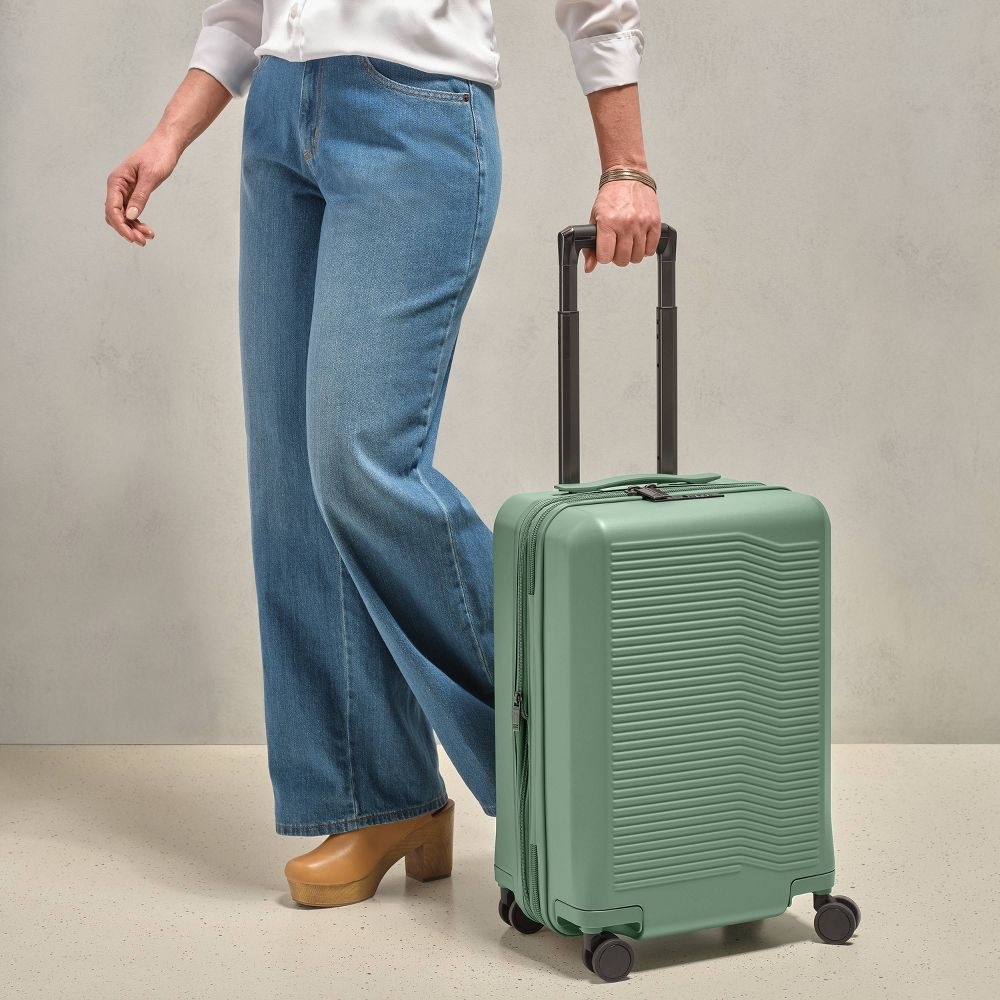 a model wheeling the carry on luggage