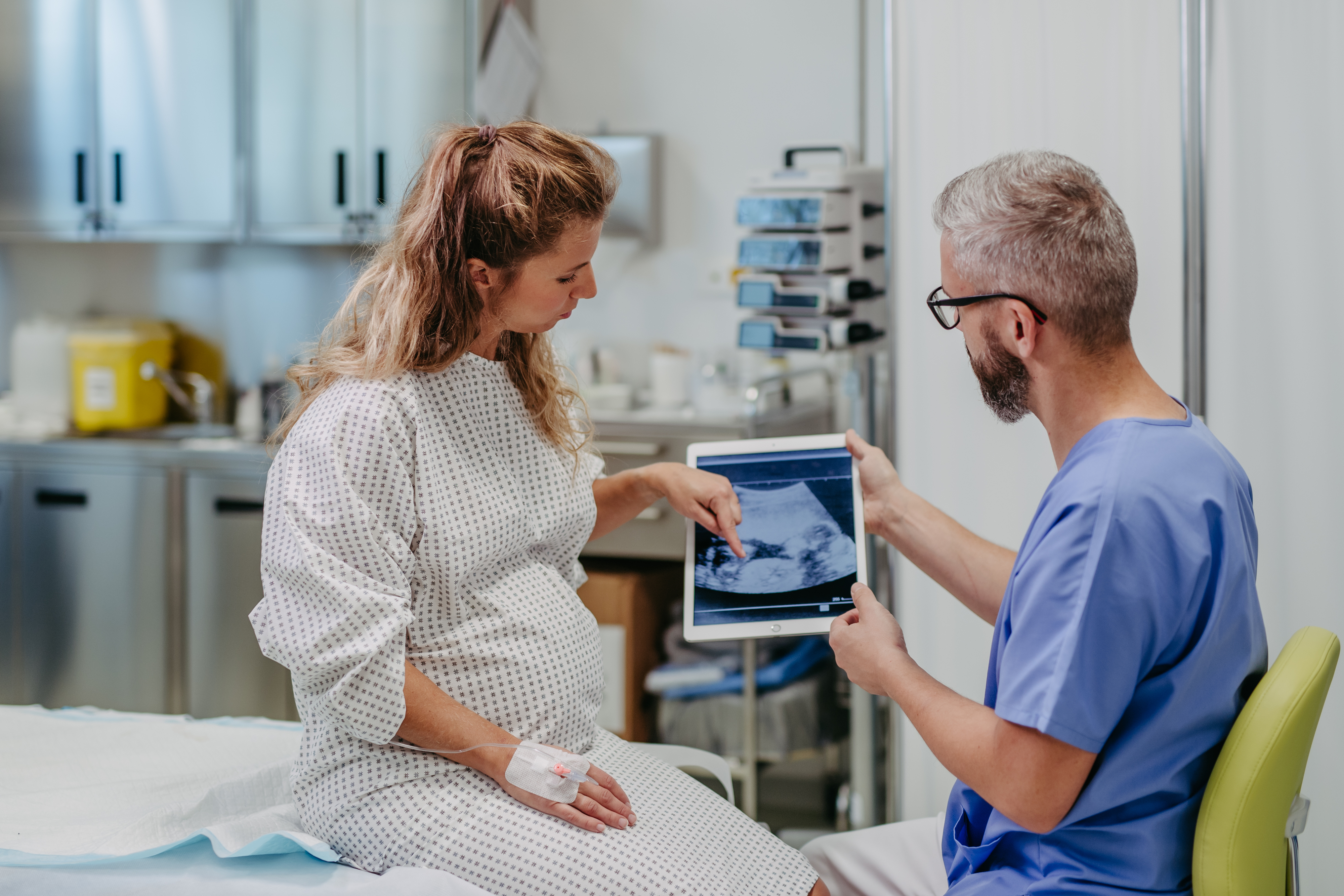 a woman looking at her ultrasound with the doctor