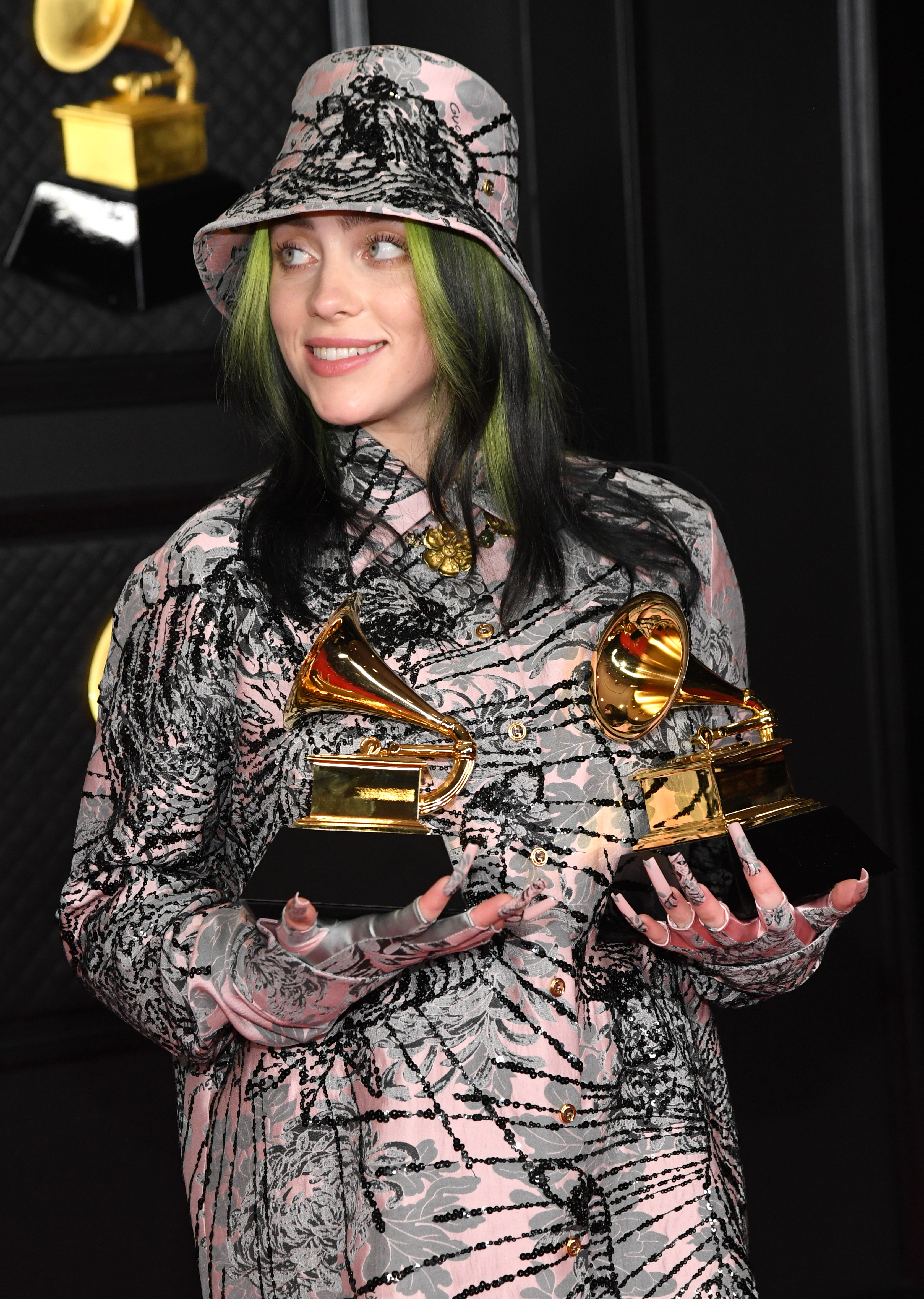 Close-up of Billie smiling and holding two Grammys