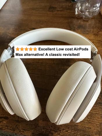 A reviewer's white headphones with review text 