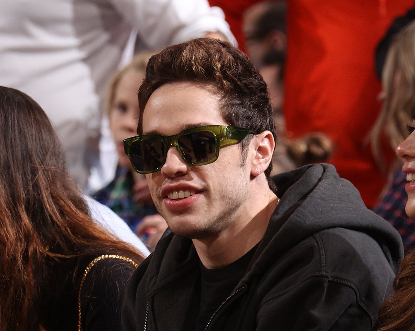 he&#x27;s sitting down wearing sunglasses with grown-out hair