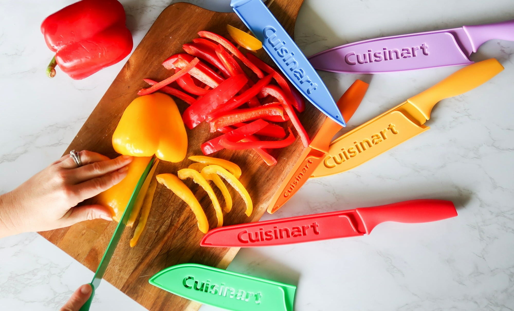 the different colored knives on a cutting board