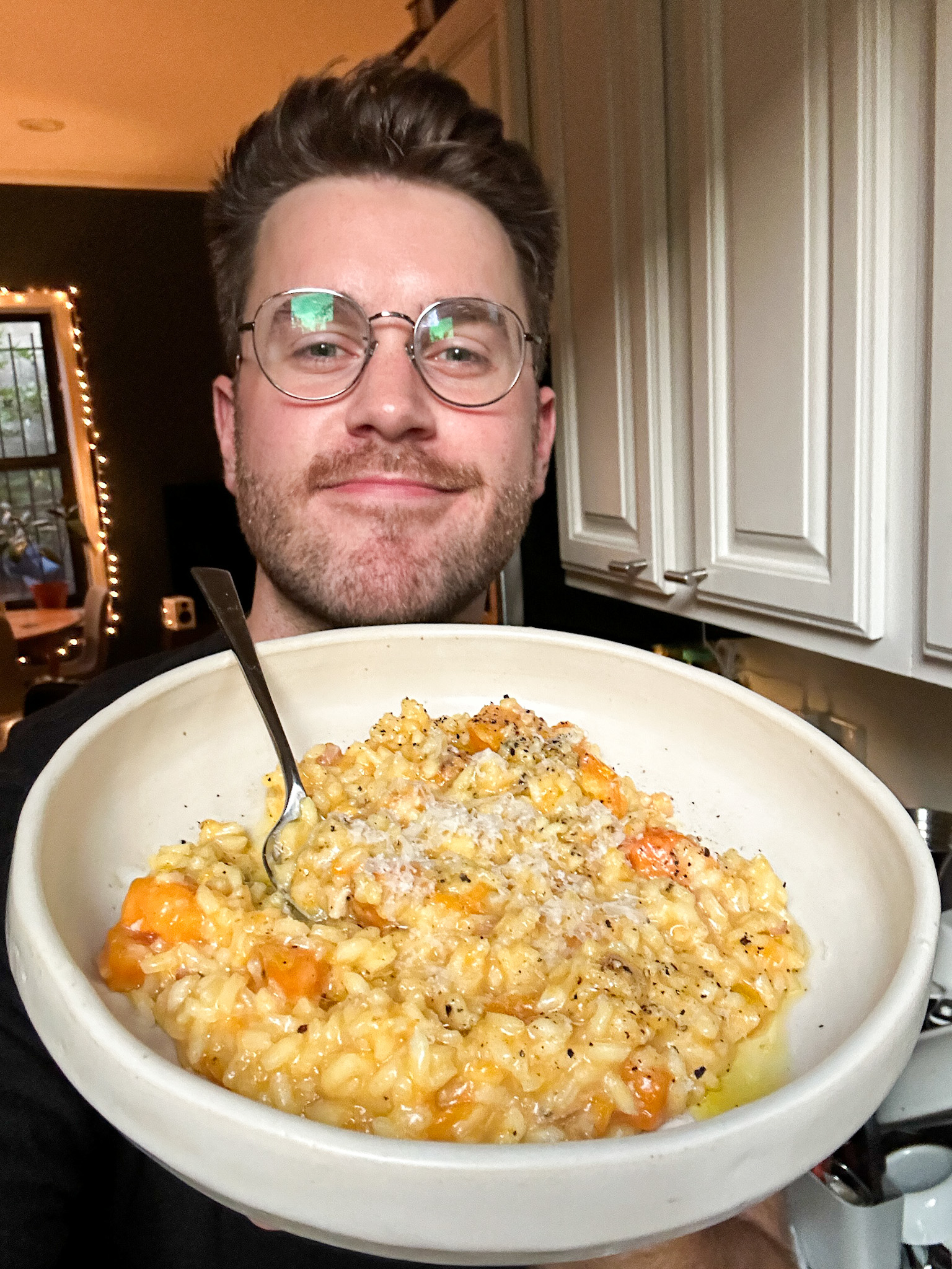 Selfie of the author holding up a bowl of the risotto in his kitchen