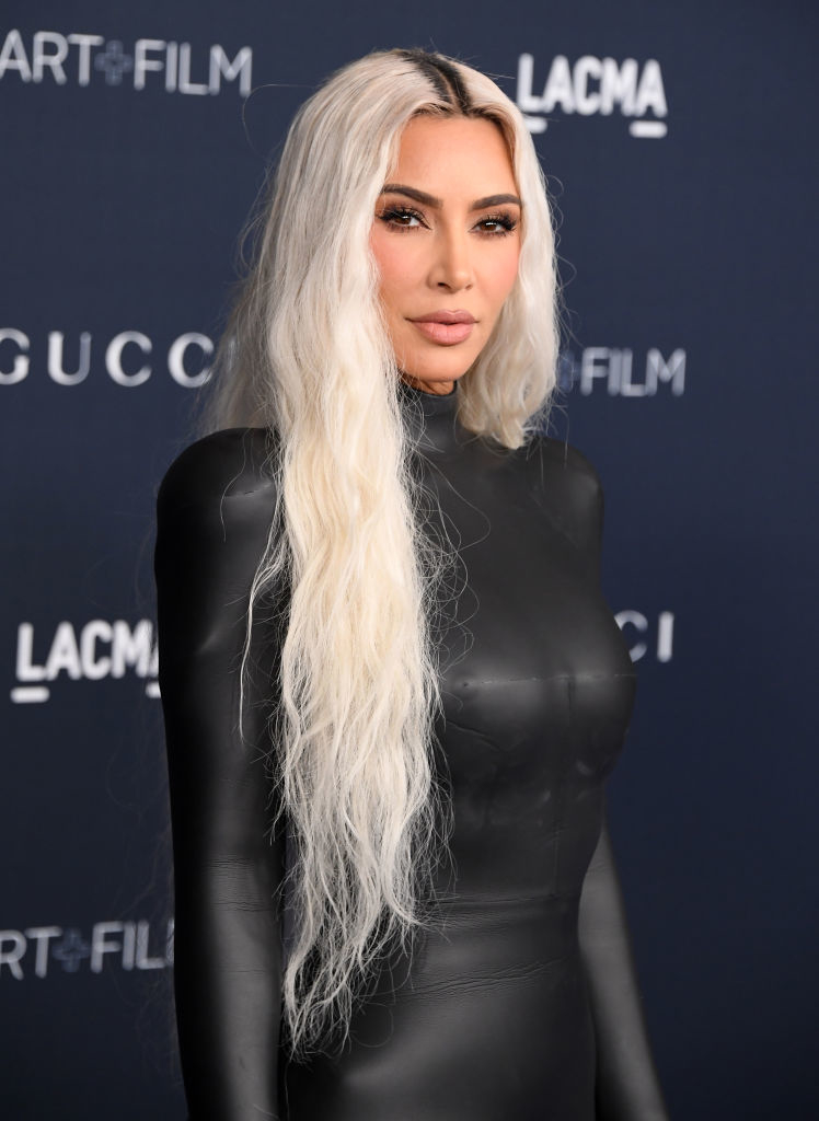 closeup of her in a leather jumpsuit with long blonde hair