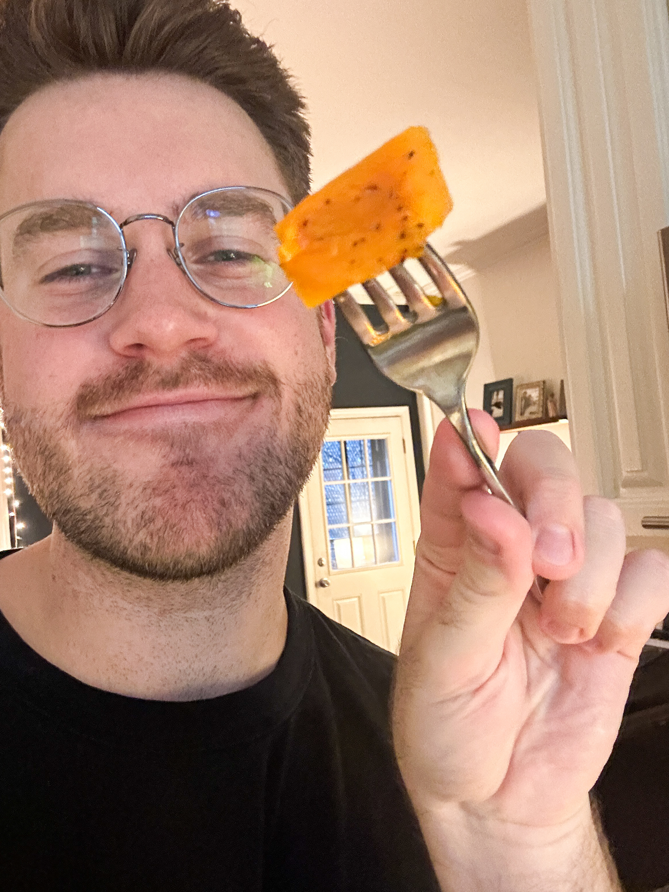 Author holding up one piece of butternut squash as a snack