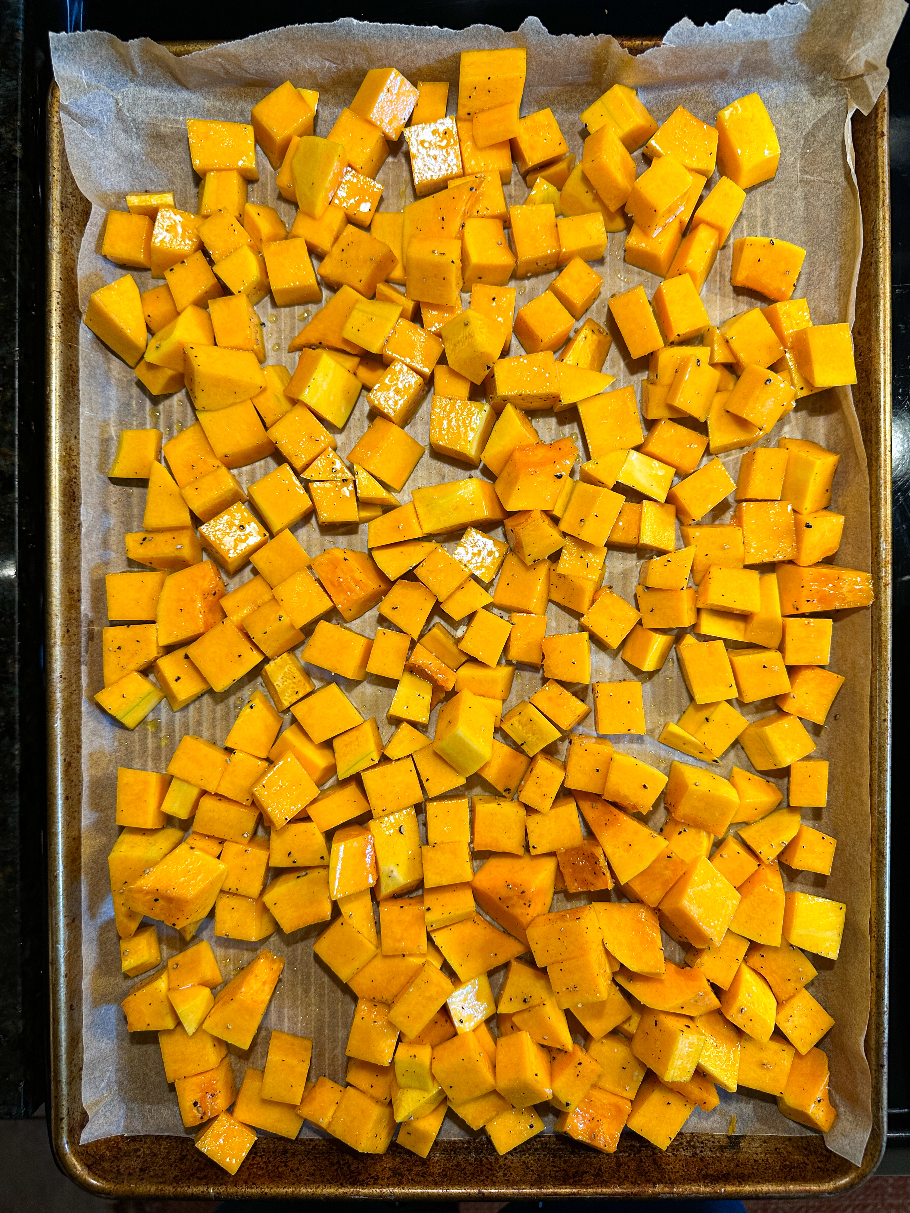 Diced butternut squash on a sheet pan, uncooked