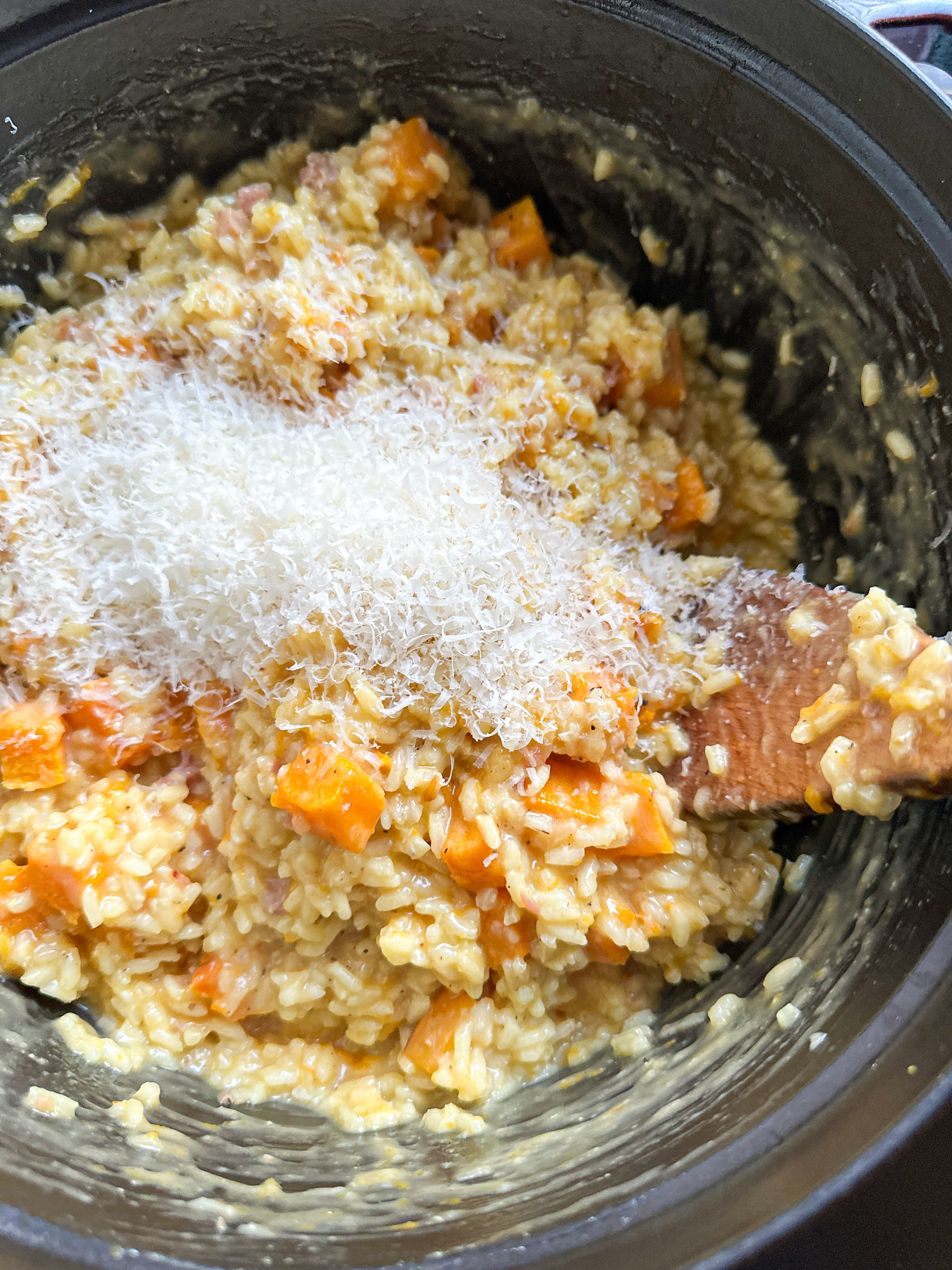 Grated Parmesan cheese on top of the risotto and butternut squash mixture