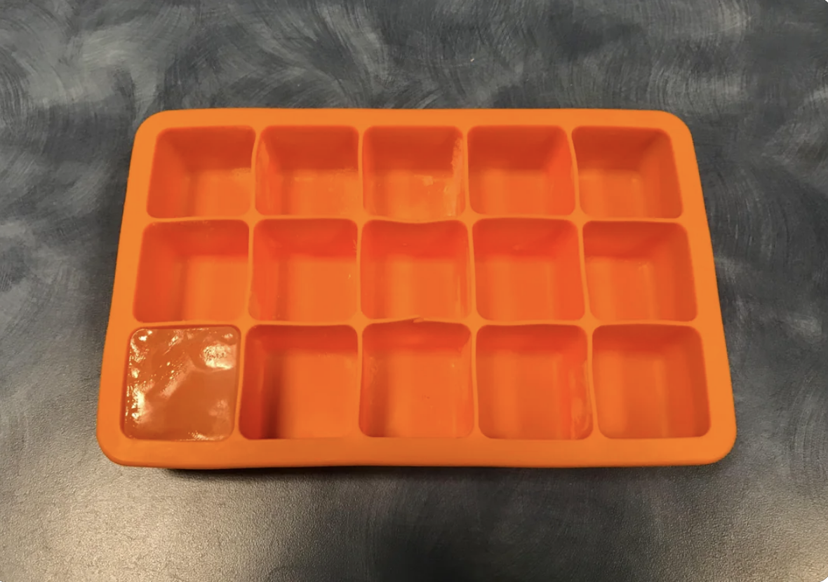 An ice tray with one ice cube