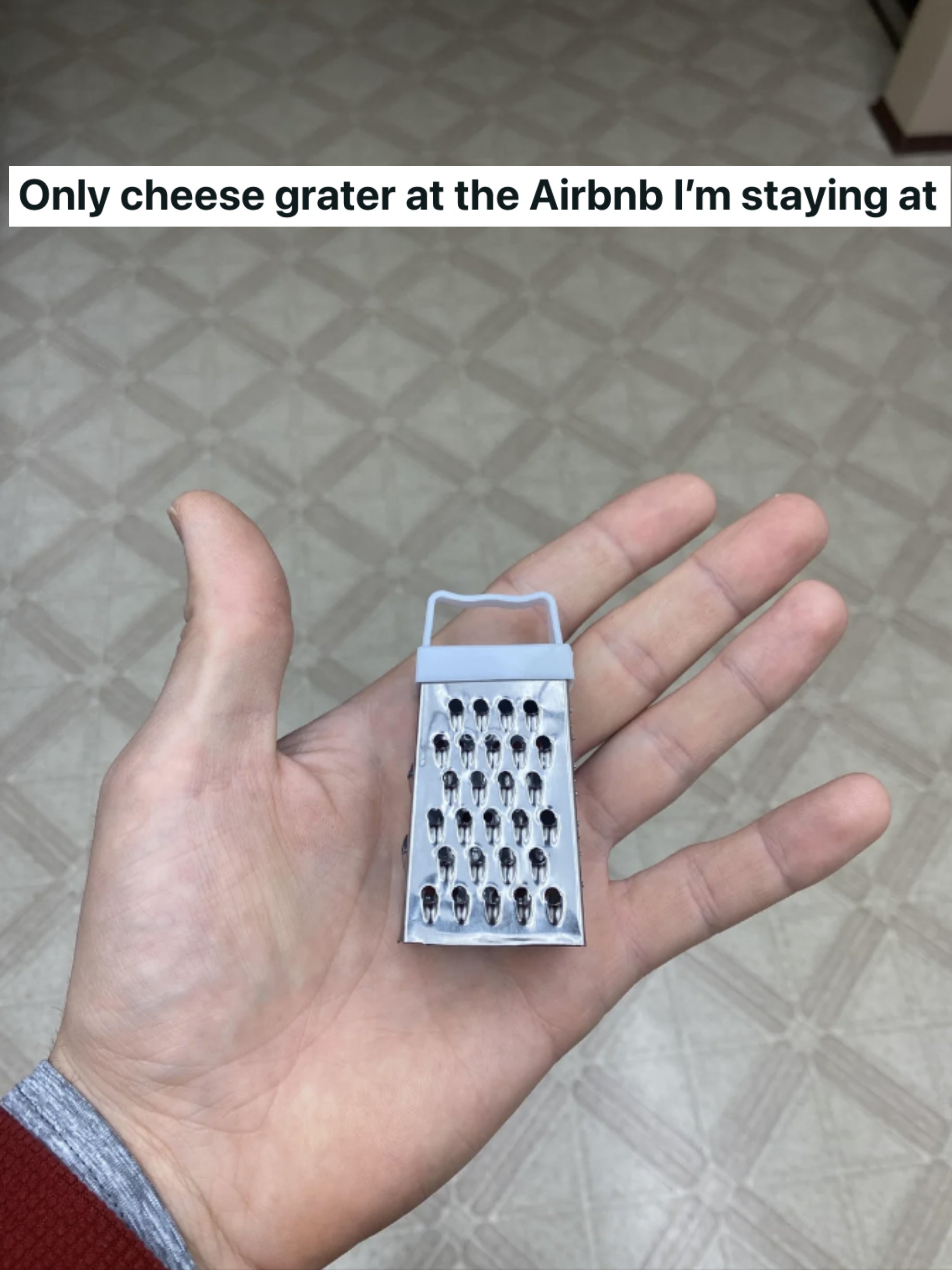 a hand holding a tiny cheese grater