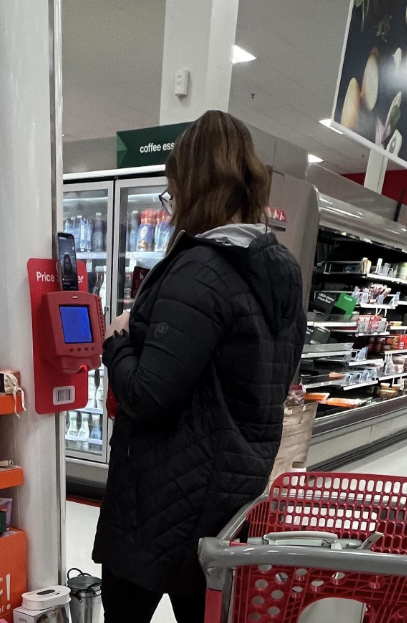 a woman filming herself using a price scanner