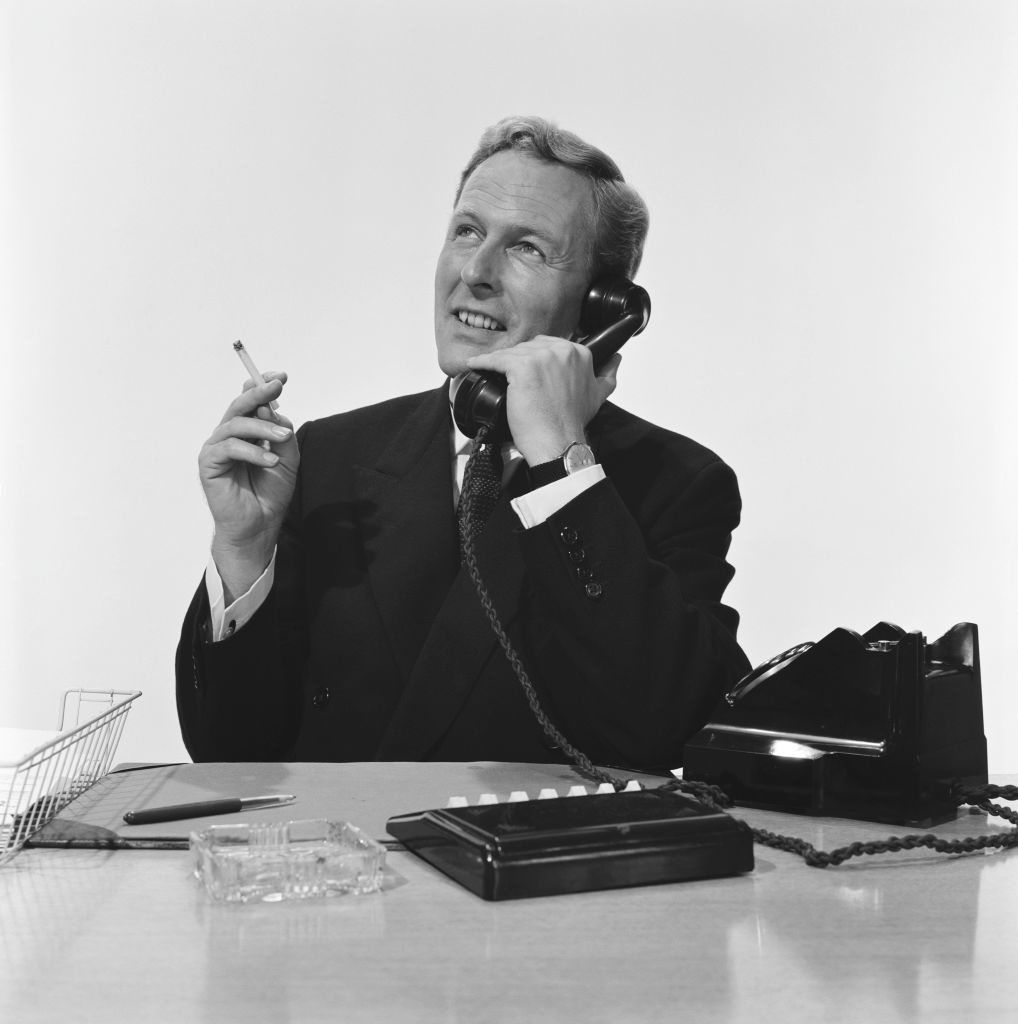 An office worker smoking while on the phone
